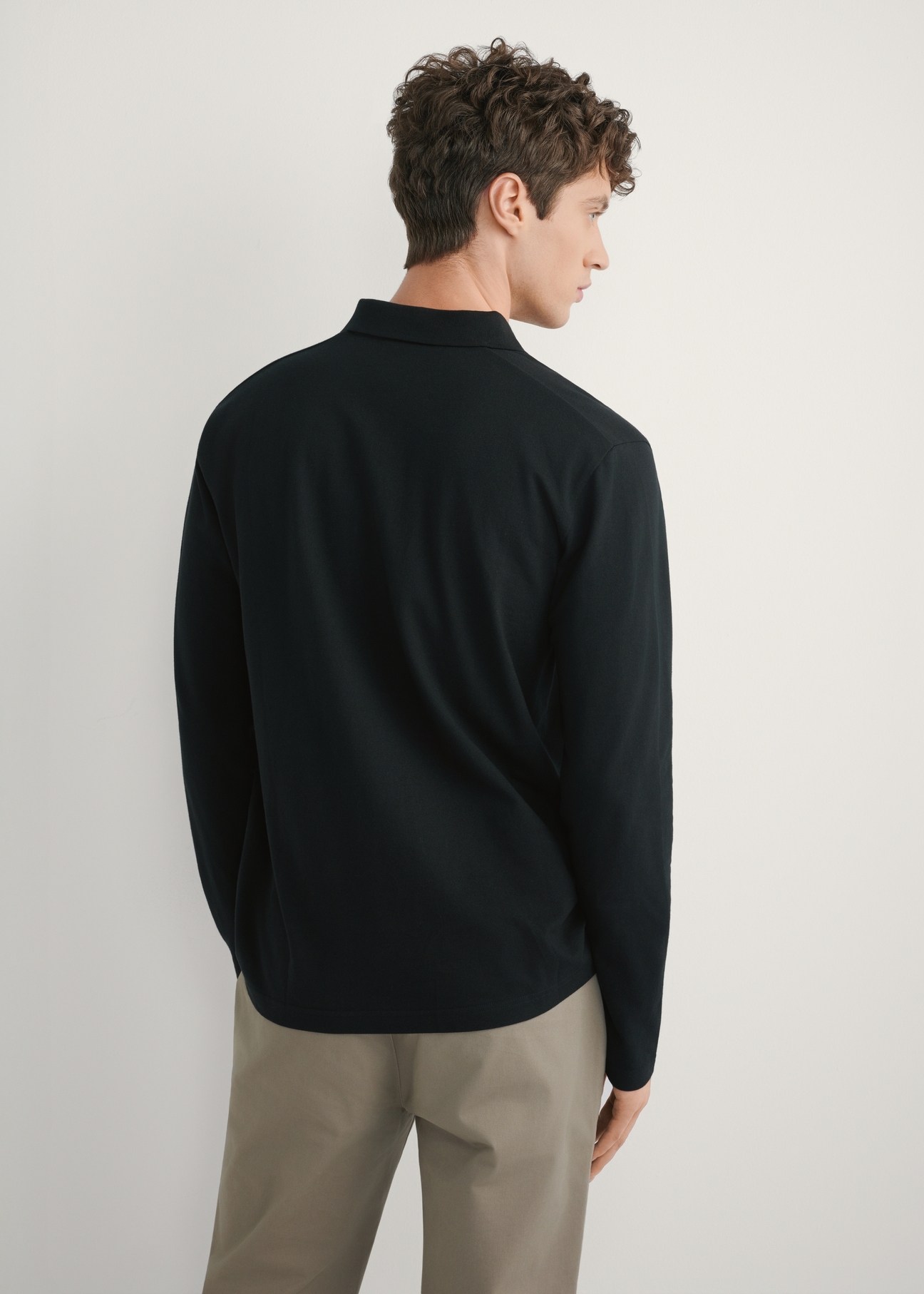 Czarny longsleeve męski z kołnierzykiem LSLMT-0011-99(W26), widok produktu z tyłu na modelu. Widoczna połowa sylwetki.