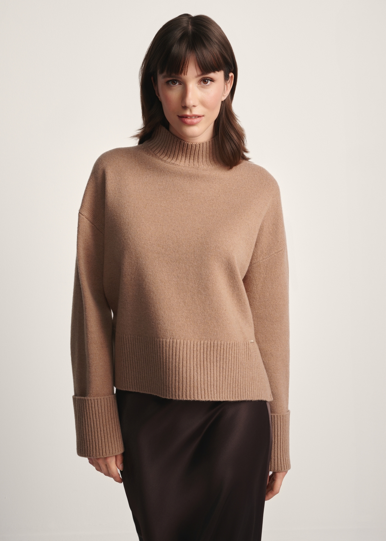Camelowy sweter damski z wełny SWEDT-0244-24(Z25), widok produktu z przodu na modelce. Widoczna połowa sylwetki.