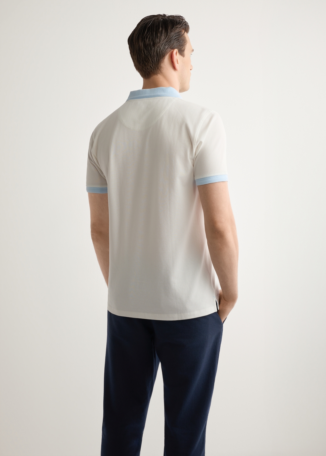 Męska kremowa koszulka polo POLMT-0093-0B(W26), widok produktu z tyłu na modelu. Widoczna połowa sylwetki.