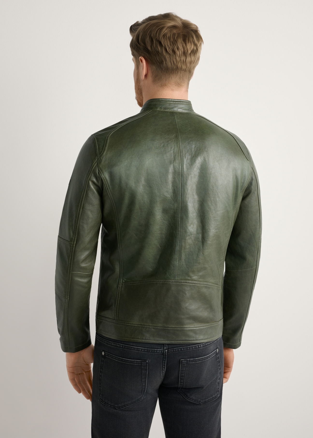 Skórzana kurtka męska w kolorze khaki KURMS-0338-8D(W26) - widok produktu z tyłu, na modelu, na jasnym tle. Widoczna połowa sylwetki.