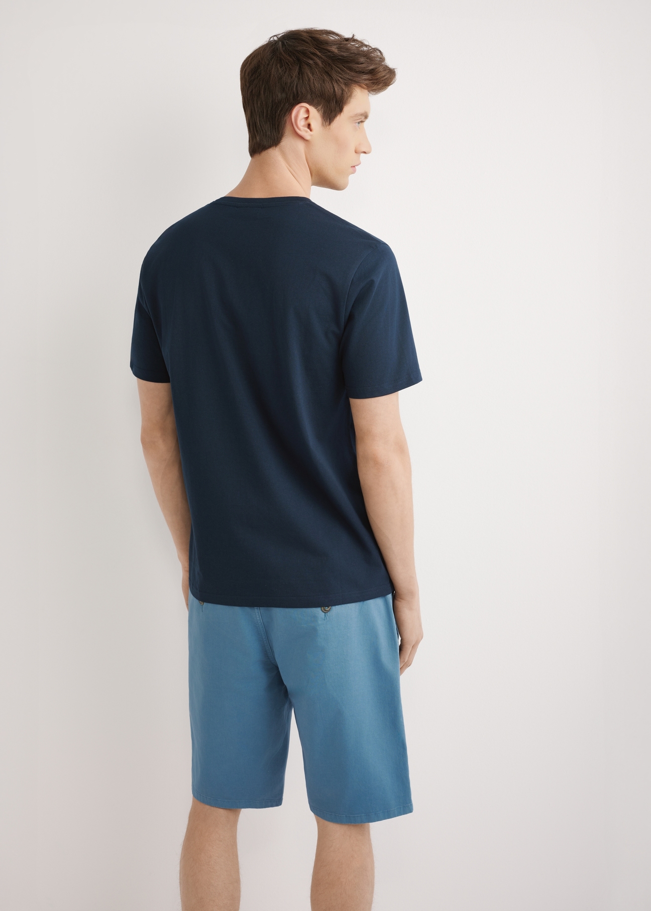 Granatowy T-shirt męski z nadrukiem TSHMT-0147-7E(W26), widok produktu z tyłu, na modelu, na jasnym tle. Widoczna połowa sylwetki.