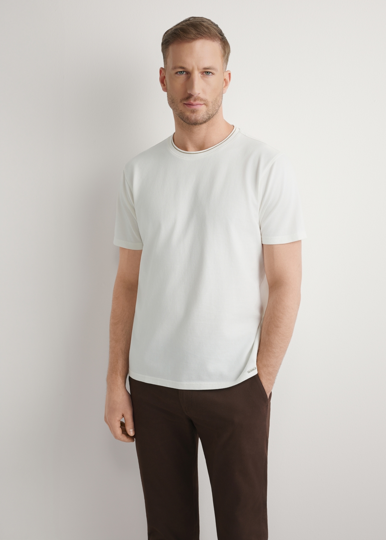 Biały T-shirt męski z bawełny TSHMT-0150-0B(W26), widok produktu z przodu na modelu. Widoczna połowa sylwetki.