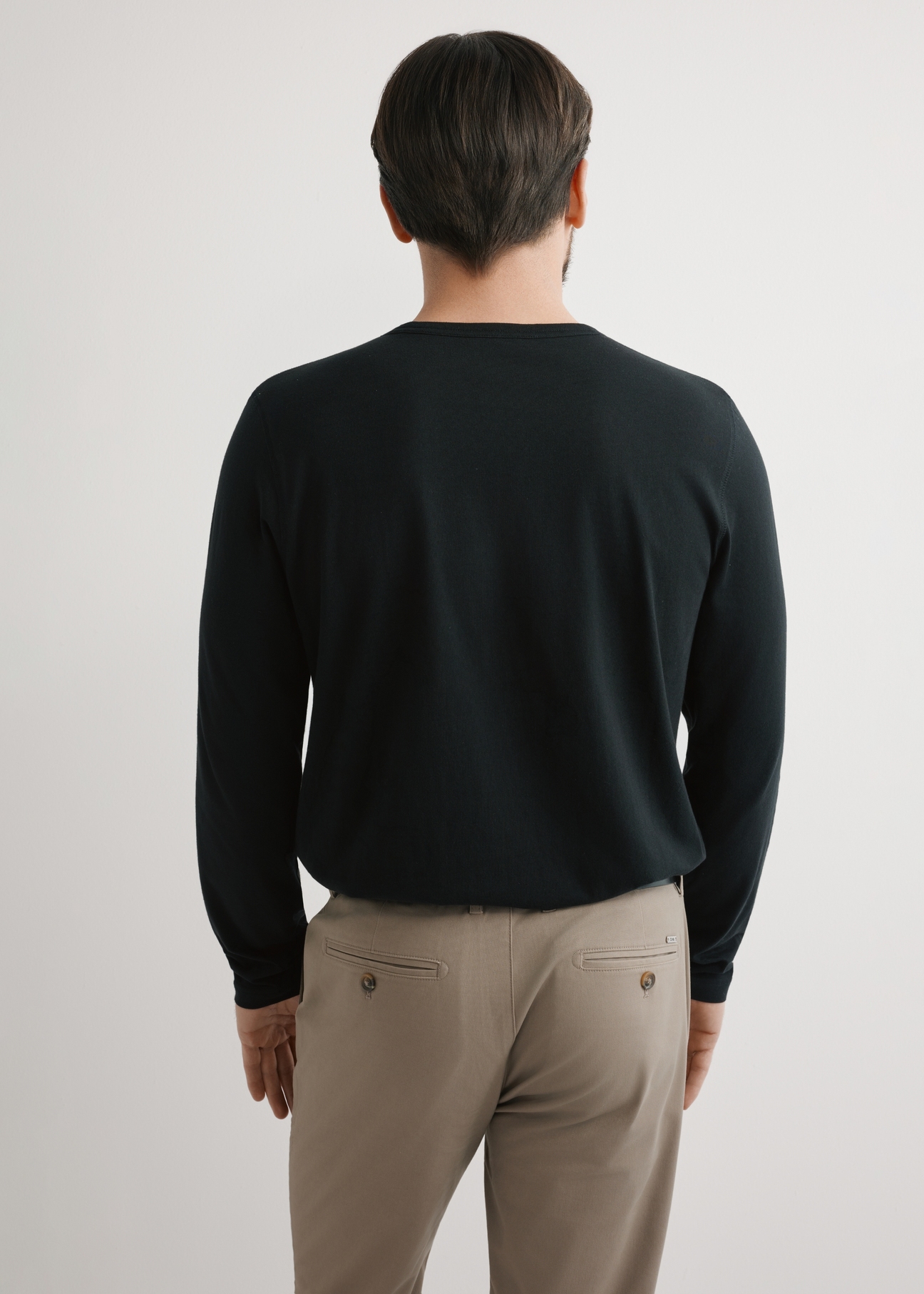 Czarny bawełniany longsleeve męski LSLMT-0010-99(W26), widok produktu z tyłu na modelu. Widoczna połowa sylwetki.