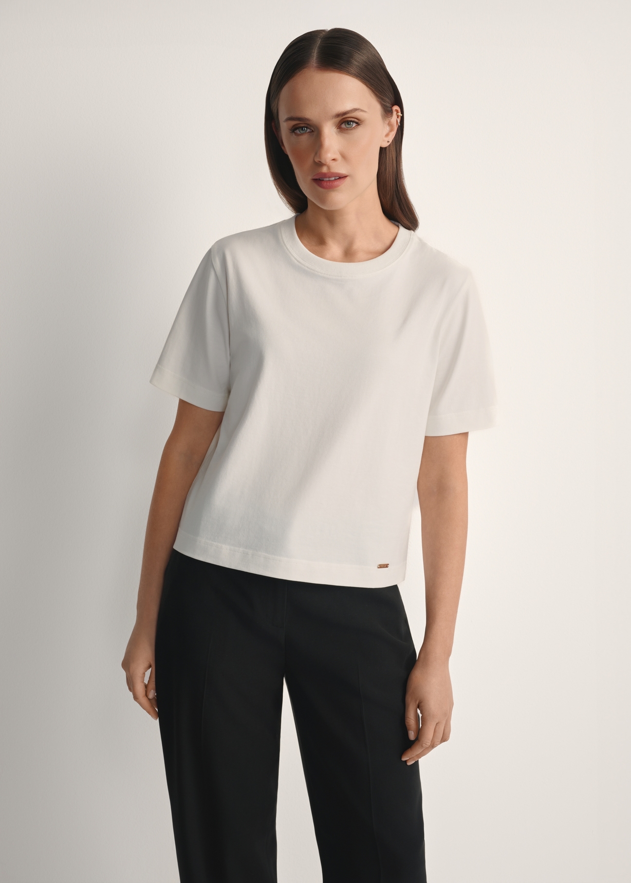 Bawełniany kremowy T-shirt damski TSHDT-0138-0B(W26), widok produktu od przodu na modelce, widoczna połowa sylwetki.