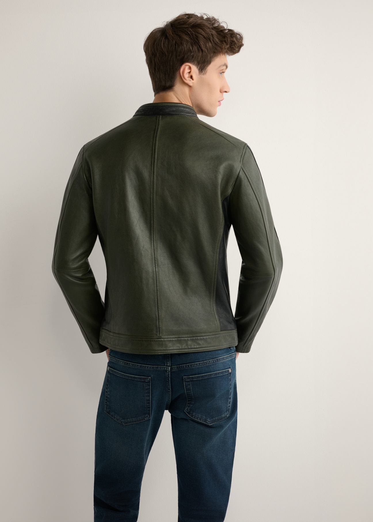 Skórzana kurtka męska w kolorze khaki KURMS-0399-8D(W26) - widok produktu z tyłu, na modelu, na jasnym tle. Widoczna połowa sylwetki. 