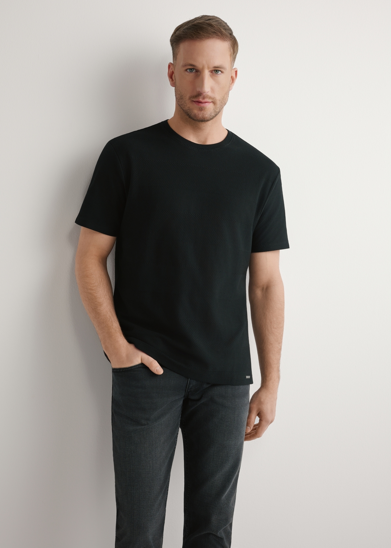 Czarny prążkowany t-shirt męski TSHMT-0142-99(W26), widok produktu z przodu na modelu. Widoczna połowa sylwetki.