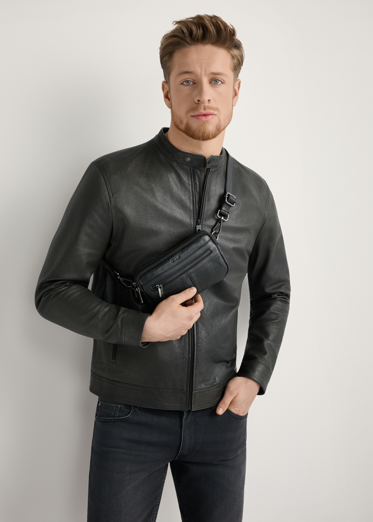 Mała czarna skórzana torba męska TORMS-0492-99(W26), widok produktu od przodu na modelu, widoczna cała sylwetka.