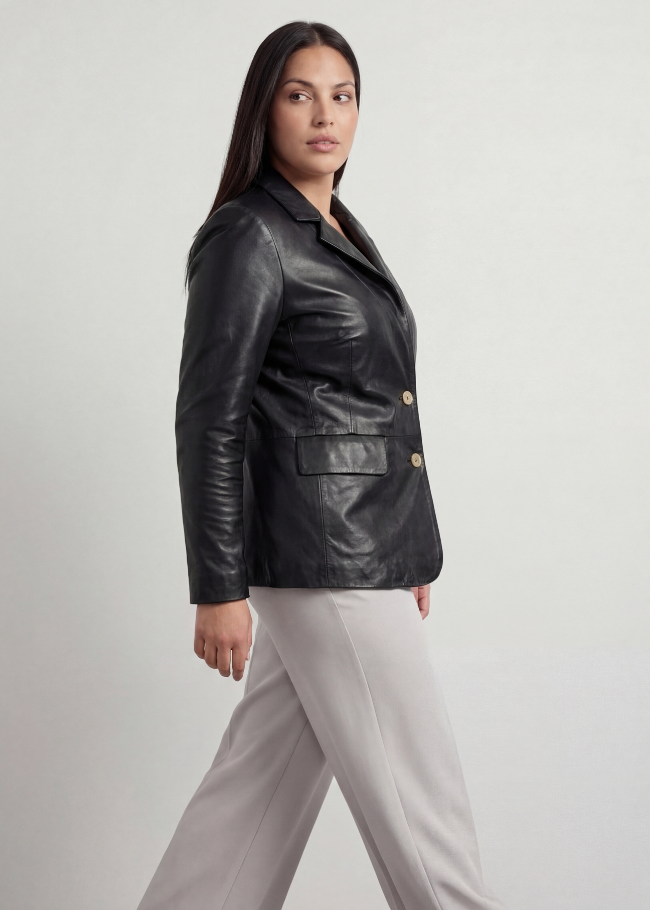Czarna skórzana marynarka damska PLUS SIZE KURDS-0645L-99(W26), widok produktu od boku na modelce, widoczna połowa sylwetki.