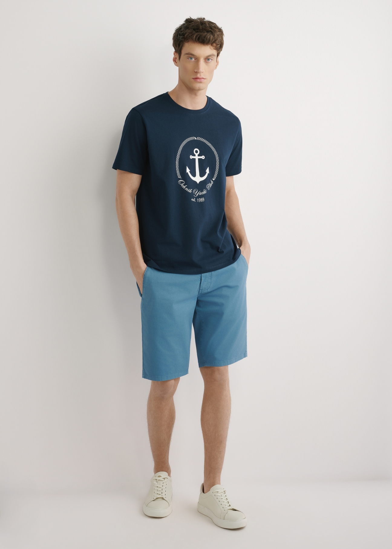 Granatowy T-shirt męski z nadrukiem TSHMT-0147-7E(W26), widok produktu z przodu, na modelu, na jasnym tle. Widoczna cała sylwetka.
