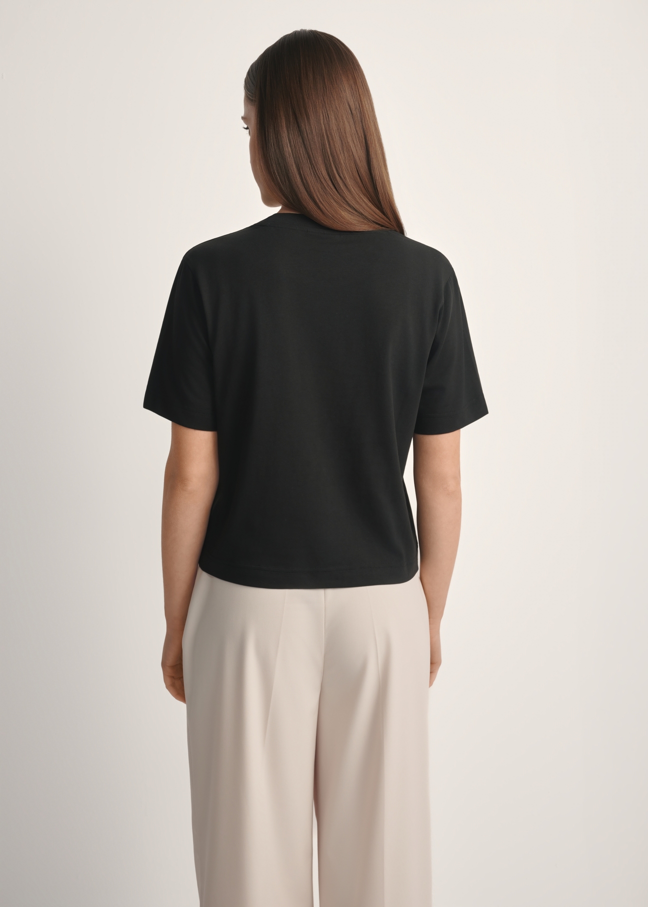 Bawełniany czarny T-shirt damski TSHDT-0138-99(W25), widok produktu od tyłu na modelce, widoczna połowa sylwetki.