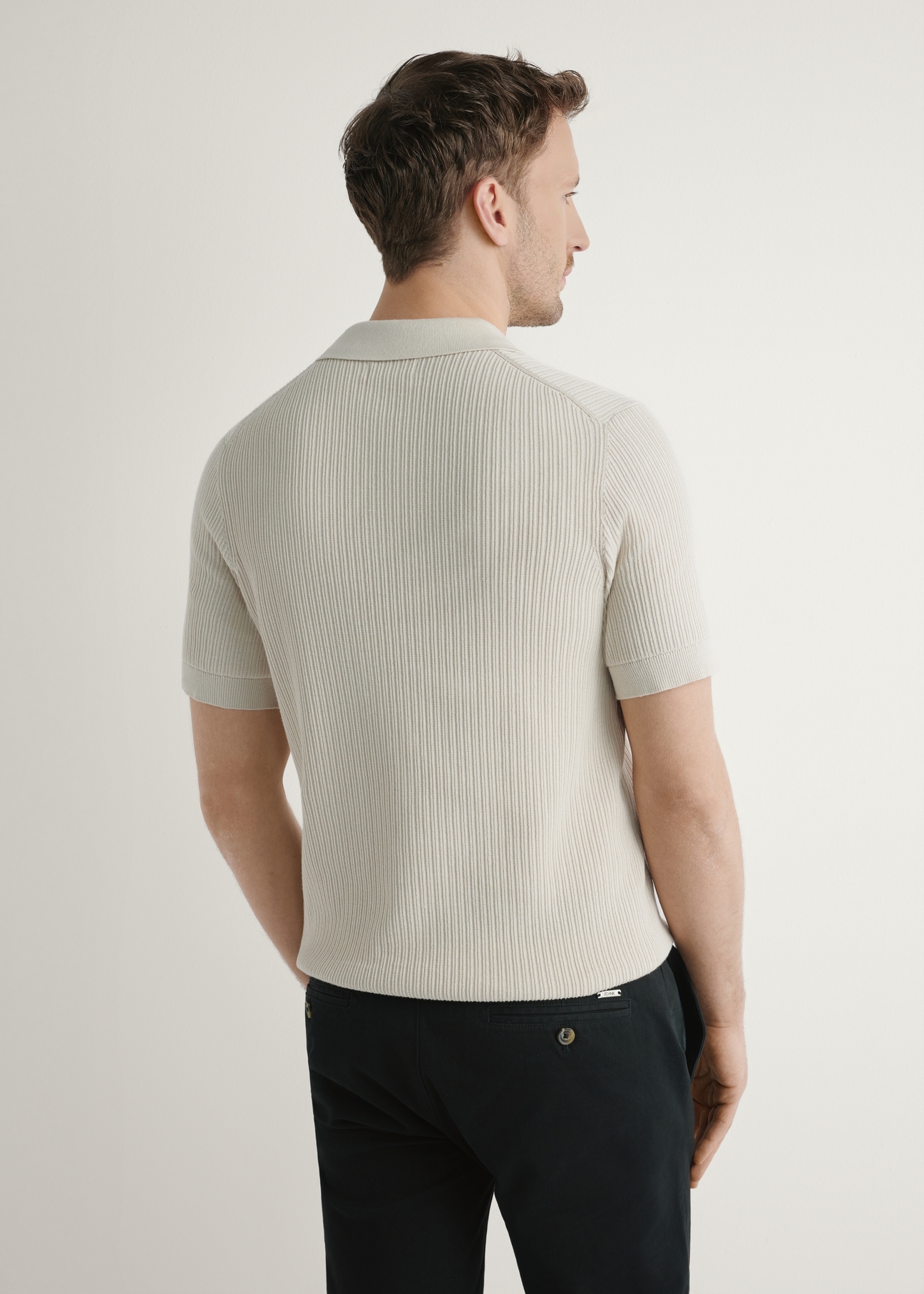 Jasnobeżowa prążkowana koszulka polo POLMT-0085-1A(W26), widok produktu z tyłu na modelu. Widoczna połowa sylwetki.