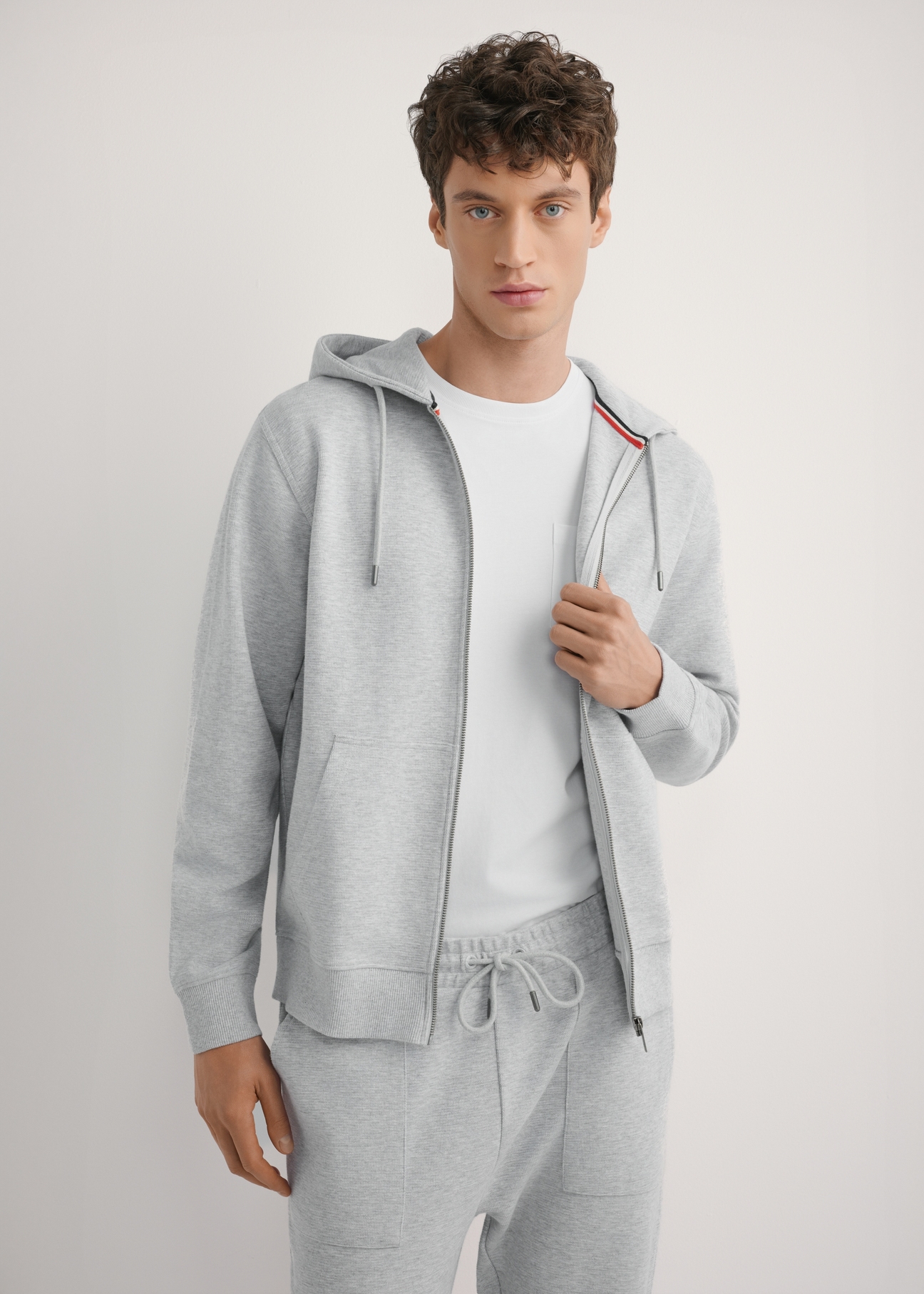 Szara bluza męska z kapturem BLZMT-0079-9A(W26), widok produktu z przodu na modelu. Widoczna połowa sylwetki.