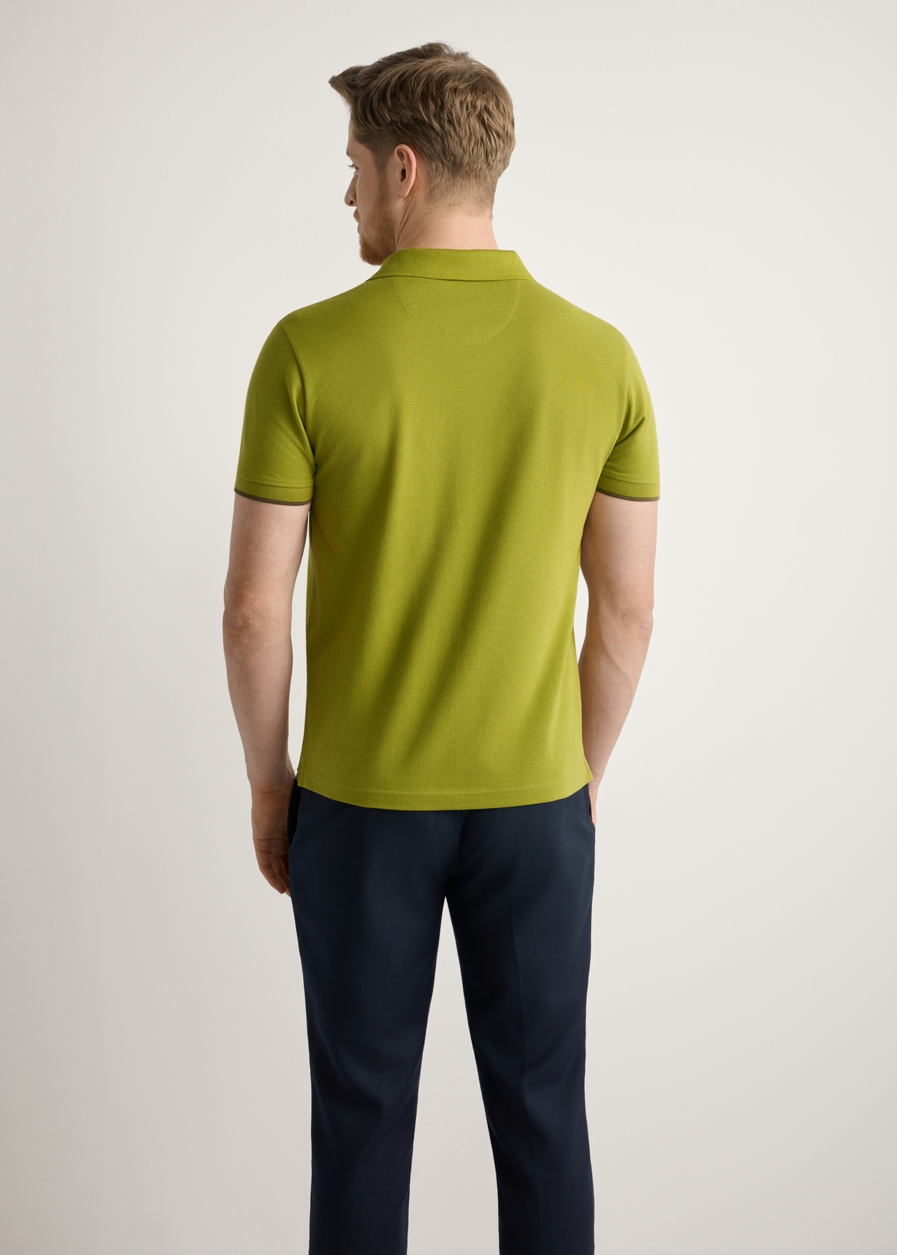 Oliwkowa koszulka polo z bawełny POLMT-0045B-8E(W26), widok produktu z tyłu na modelu. Widoczna połowa sylwetki.