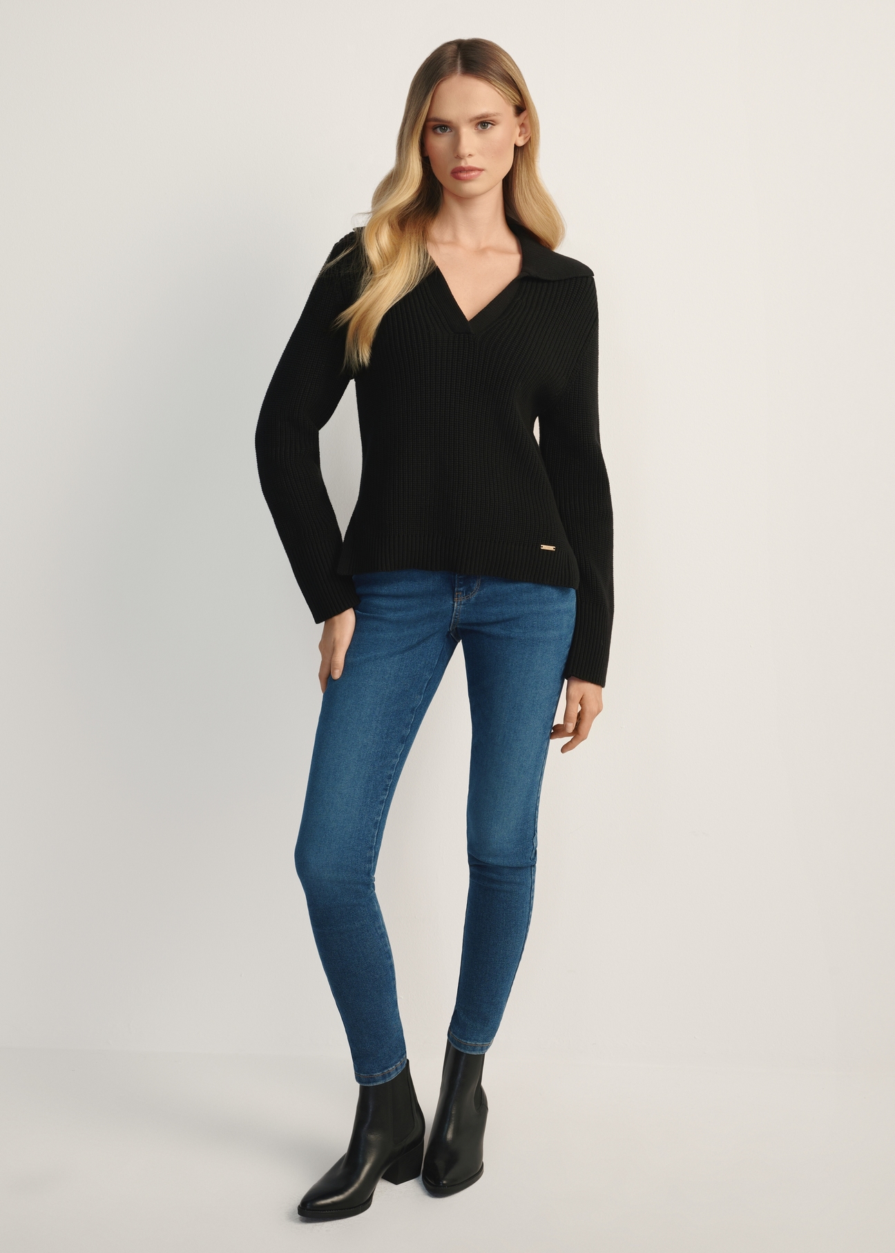 Czarny sweter damski z kołnierzykiem SWEDT-0239-99(Z25), widok produktu z przodu na modelce. Widoczna cała sylwetka.