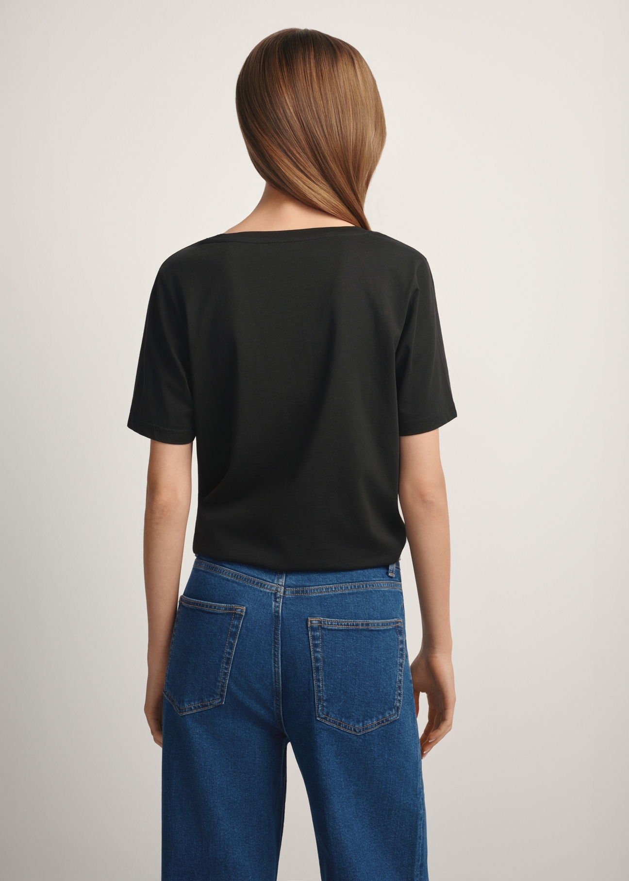 Czarny T-shirt damski basic TSHDT-0120-99(W25), widok produktu od tyłu na modelce, widoczna połowa sylwetki.