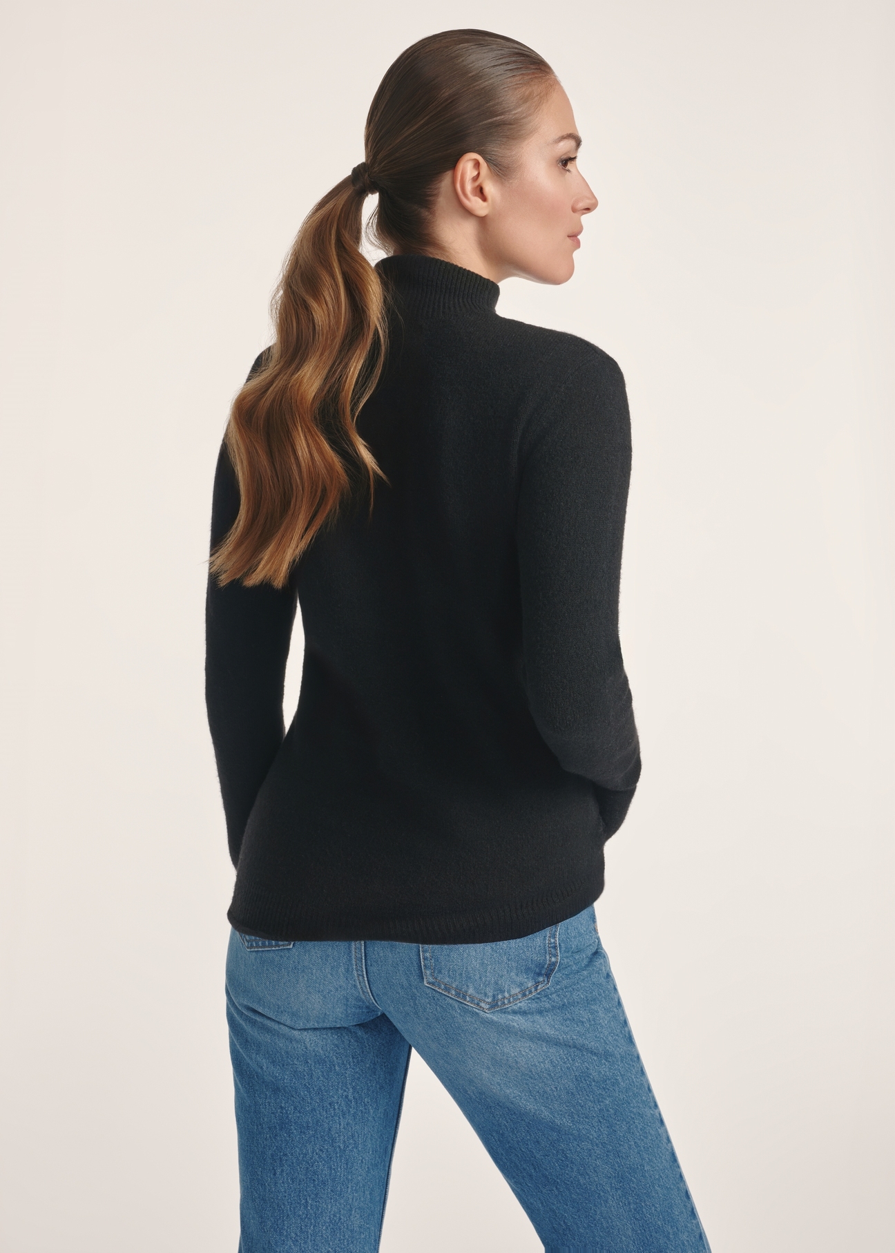 Czarny sweter damski z golfem SWEDT-0241-99(Z25), widok produktu z tyłu na modelce. Widoczna połowa sylwetki.
