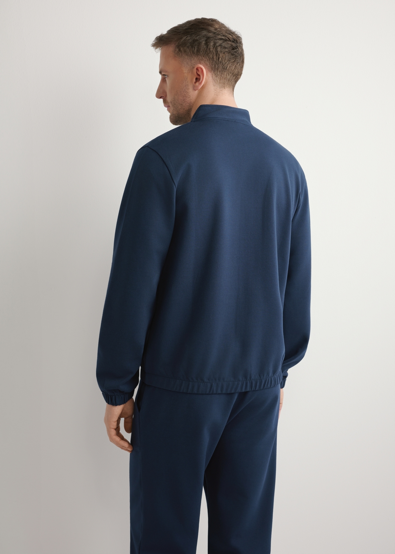 Granatowa bluza męska na suwak BLZMT-0072-7E(W26), widok produktu z tyłu na modelu. Widoczna połowa sylwetki.