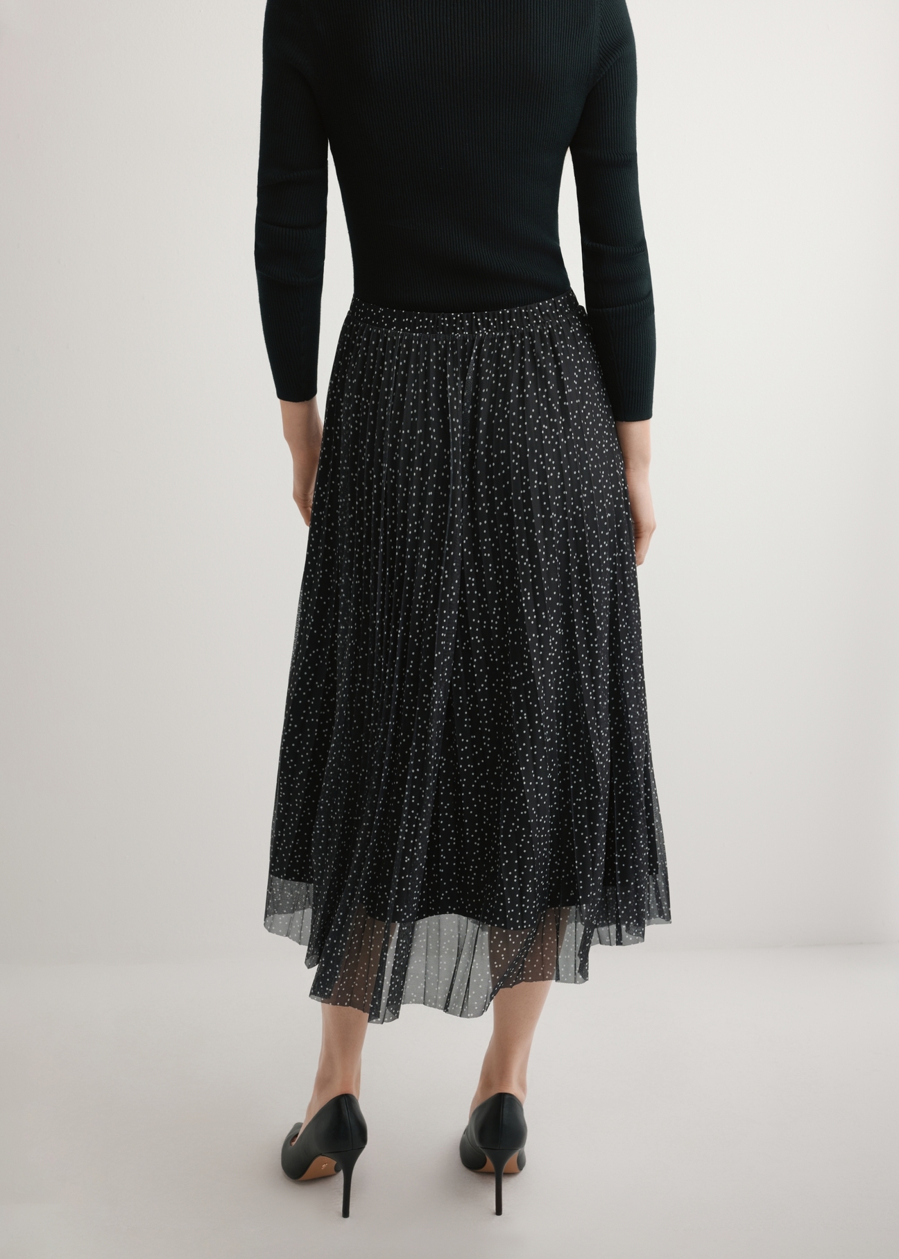 Spódnica plisowana midi w kropki SPCDT-0110-9P(W26), widok produktu od tyłu na modelce, widoczna połowa sylwetki.