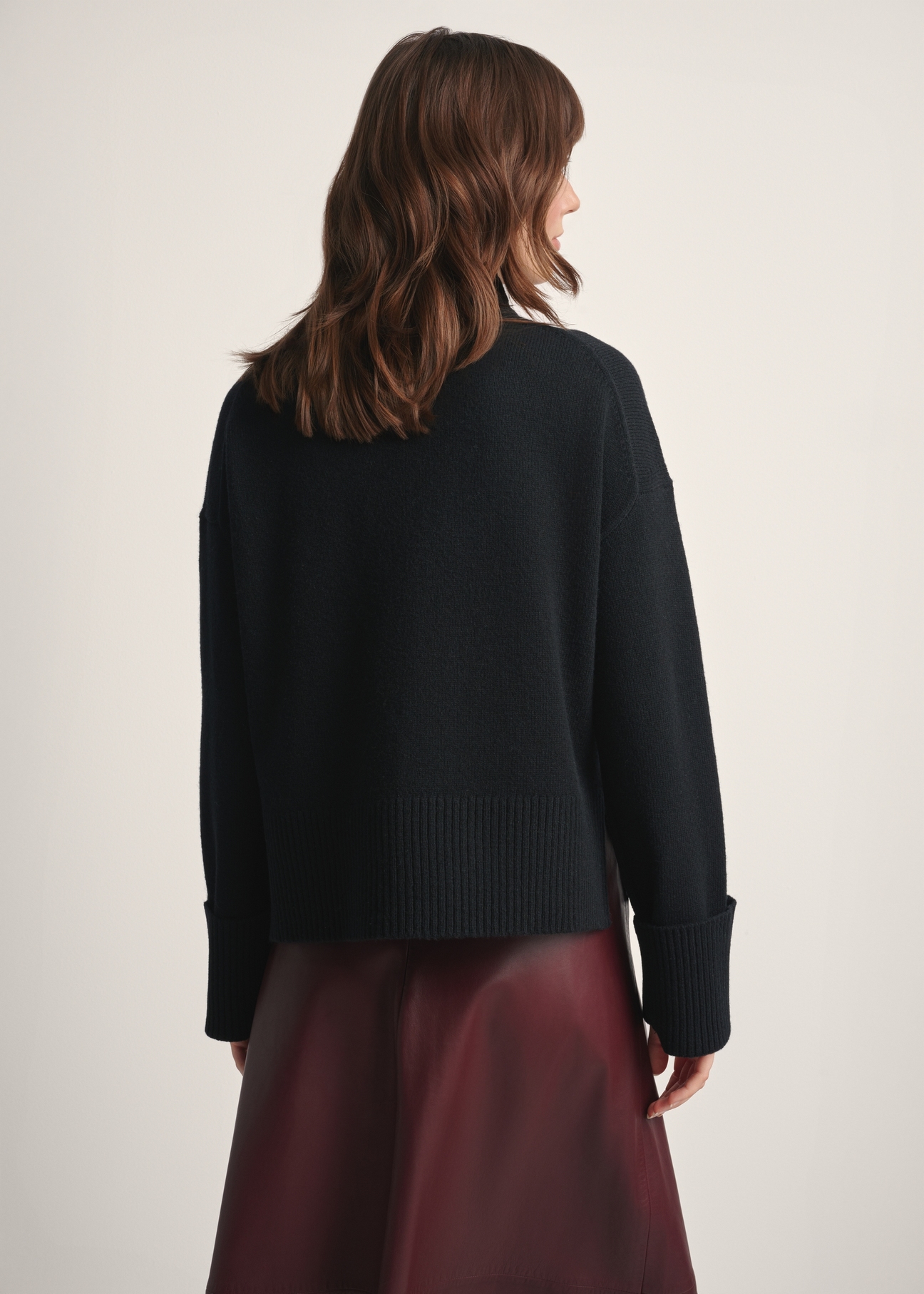 Czarny sweter damski z wełny SWEDT-0244-99(Z25), widok produktu z tyłu na modelce. Widoczna połowa sylwetki.