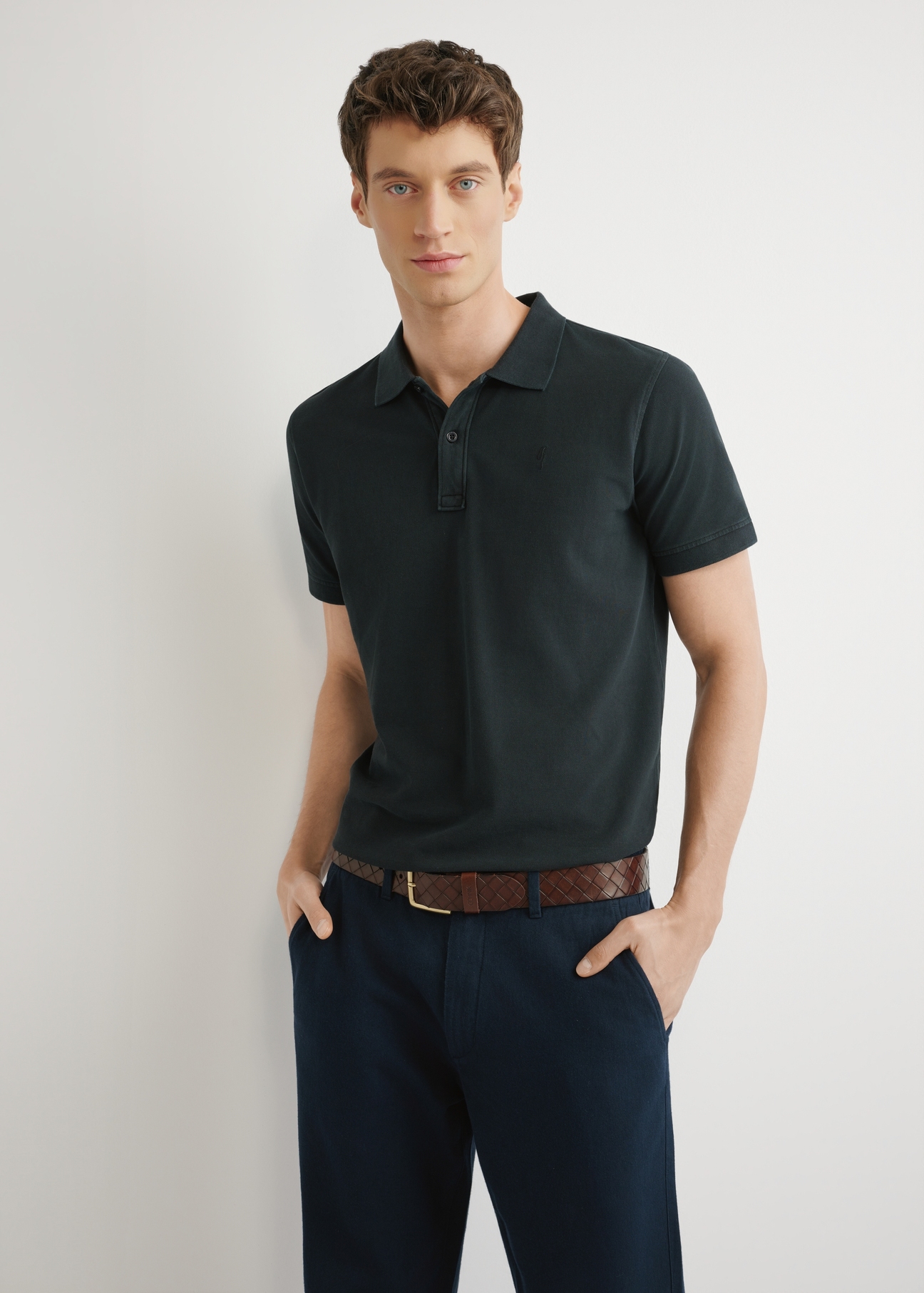 Męska koszulka polo w kolorze czarnym POLMT-0055A-99(W26), widok produktu z przodu na modelu. Widoczna połowa sylwetki.
