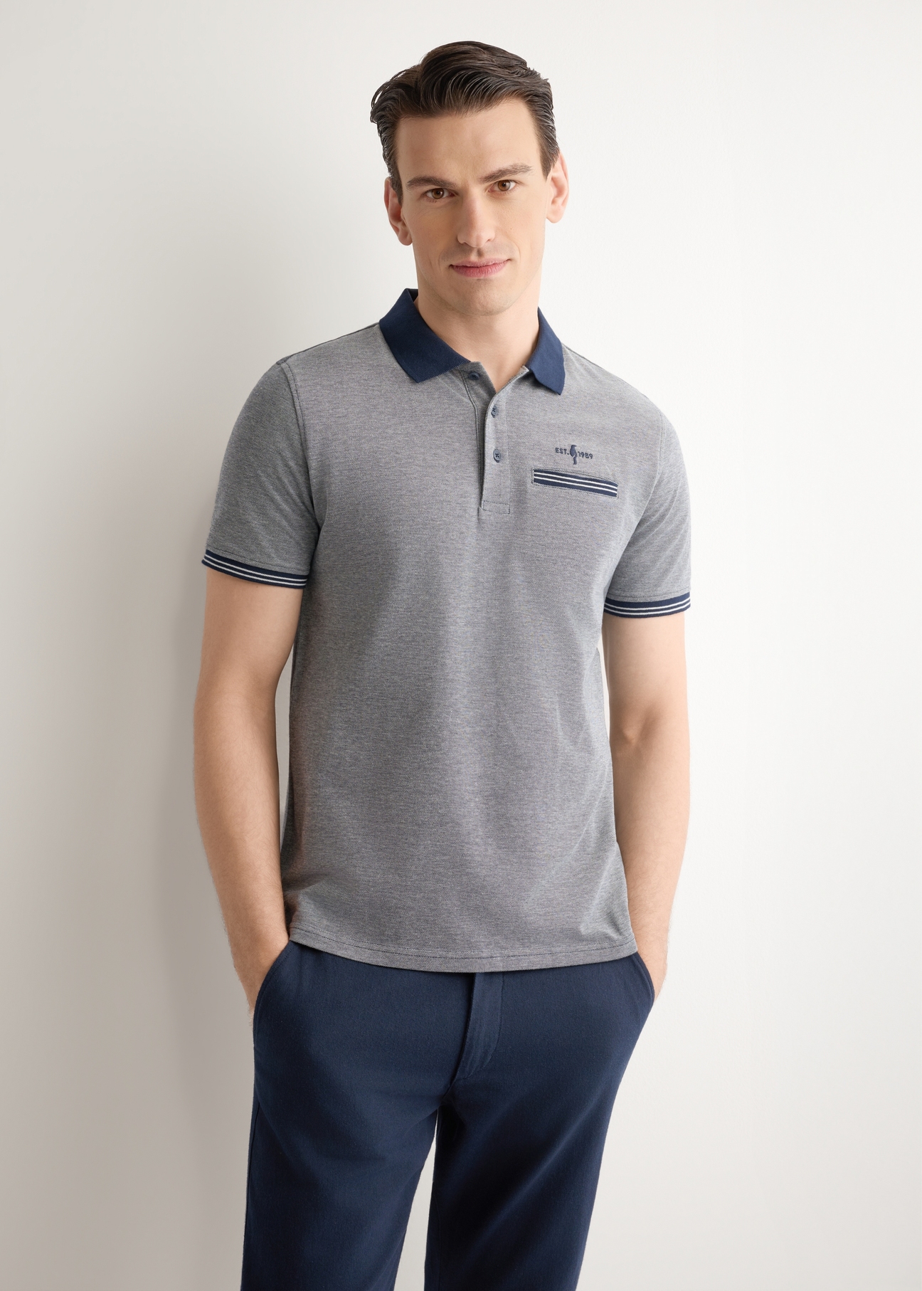 Granatowa koszulka polo męska POLMT-0068-7E(W26), widok produktu z przodu na modelu. Widoczna połowa sylwetki.