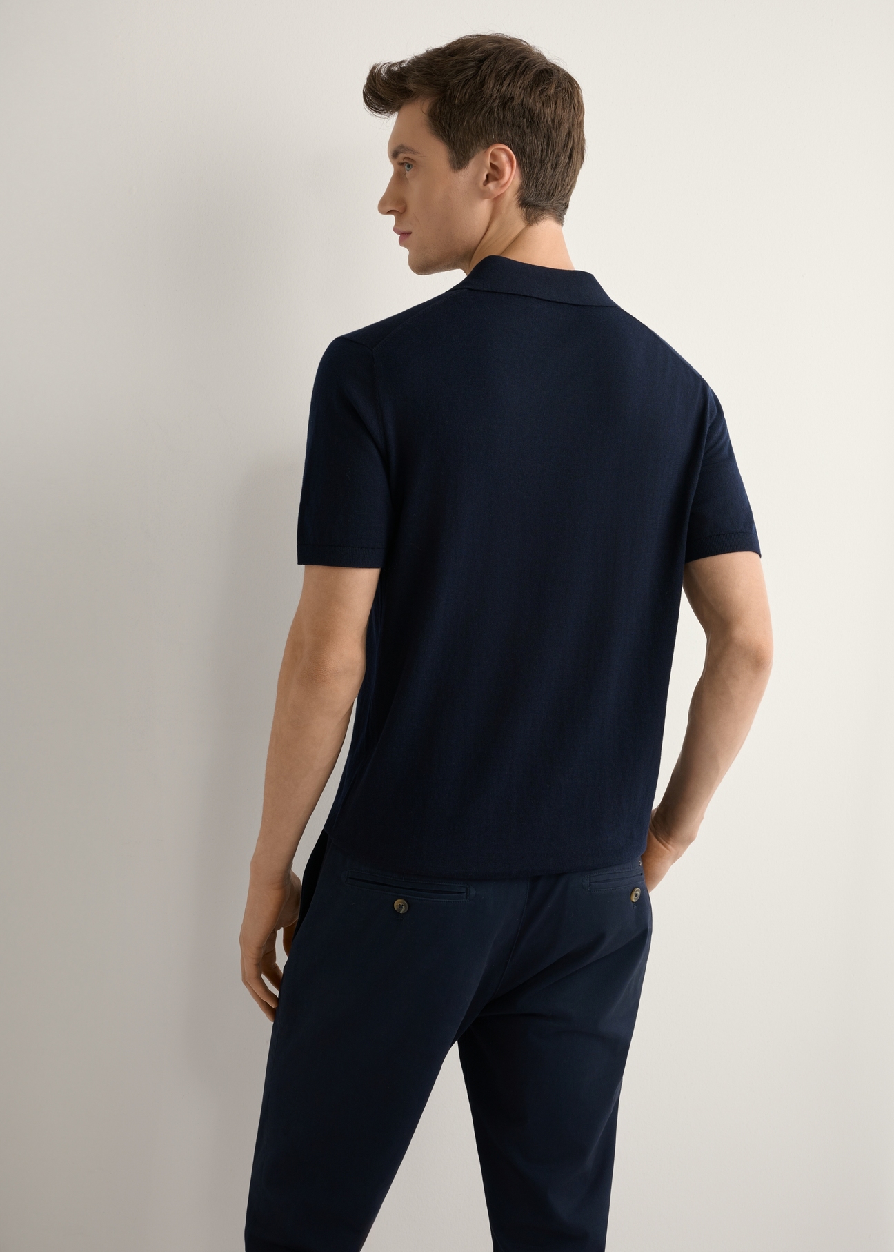 Granatowa koszulka polo z jedwabiem POLMT-0094-7E(W26), widok produktu od tyłu na modelu, widoczna połowa sylwetki.