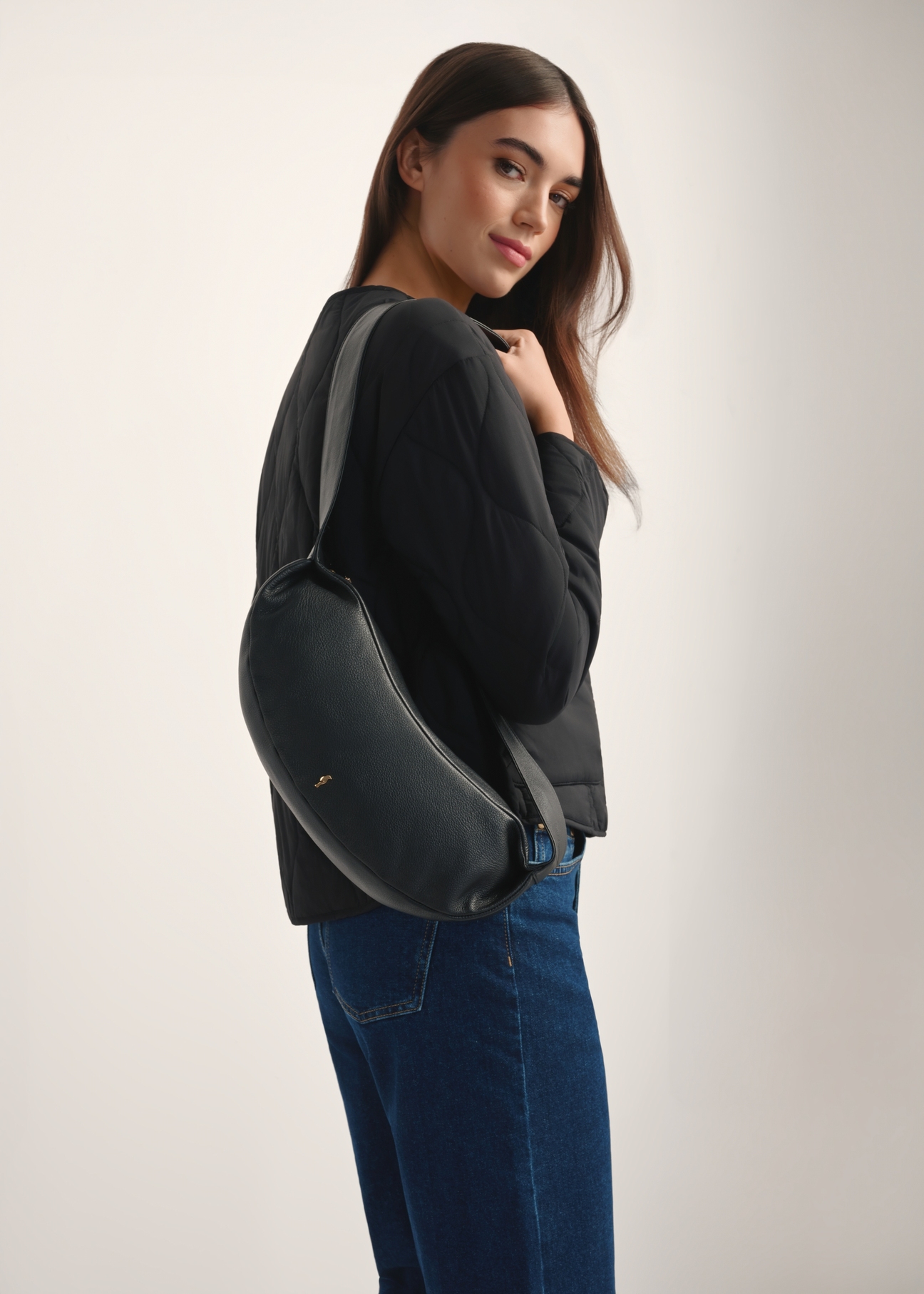 Czarna skórzana torebka w stylu bagietki TORES-1238-99(W26), widok produktu od przodu na modelce, widoczna połowa sylwetki.