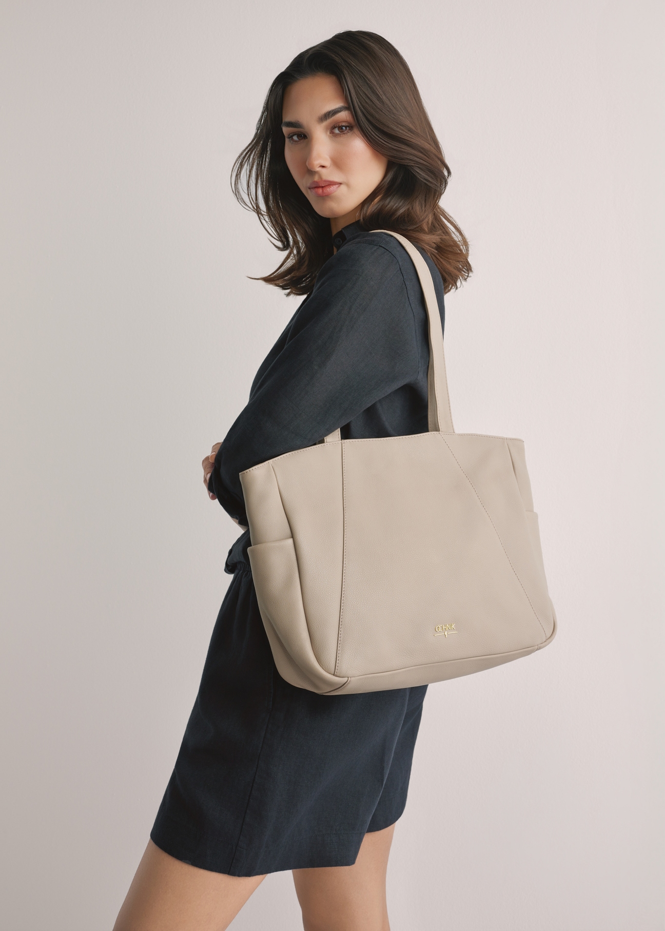 Beżowa skórzana torebka shopper damska TORES-1255-1A(W26), widok produktu na ramieniu modelki. Widoczna połowa sylwetki.