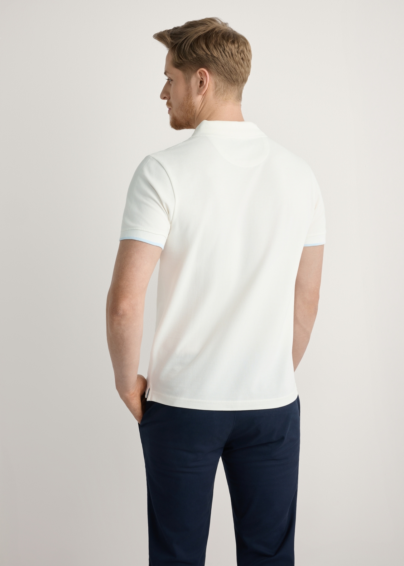 Kremowa koszulka polo z bawełny POLMT-0045B-0B(W26), widok produktu z tyłu na modelu. Widoczna połowa sylwetki.