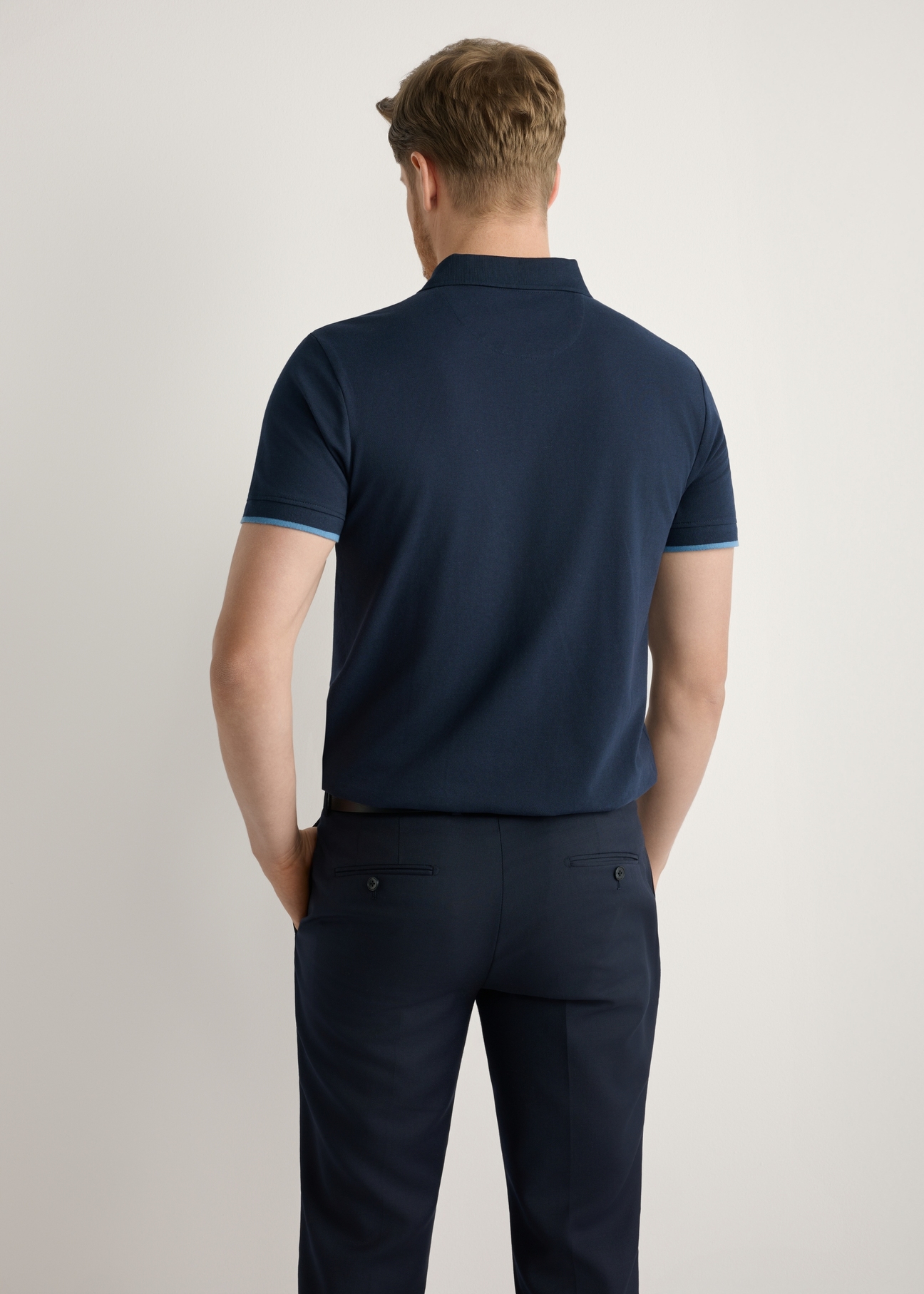 Granatowa koszulka polo z bawełny POLMT-0045B-7E(W26), widok produktu z tyłu na modelu. Widoczna połowa sylwetki.