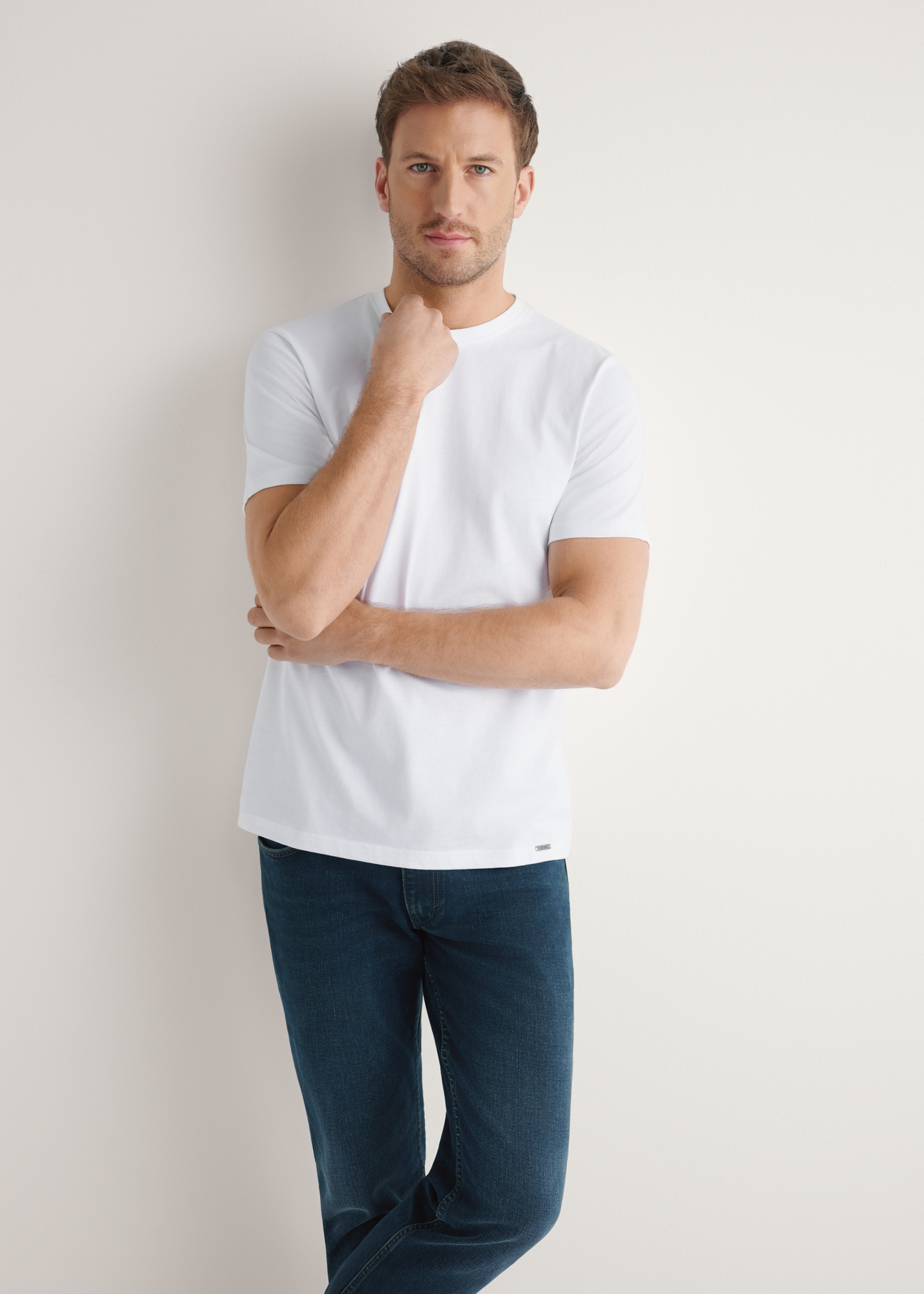 Biały bawełniany t-shirt męski TSHMT-0144-0A(W26) - widok produktu z przodu, na modelu, na jasnym tle. Widoczna sylwetka do połowy.
