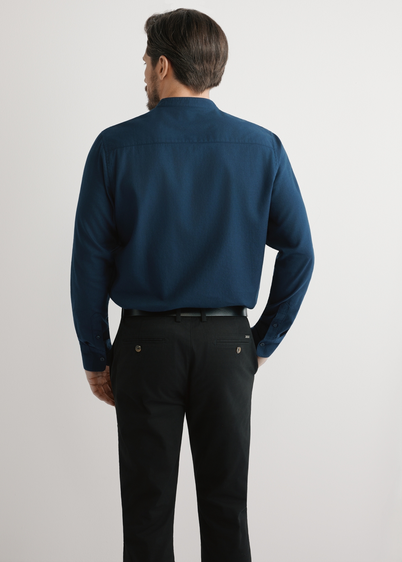 Granatowa bawełniana koszula męska KOSMT-0326-7E(W26), widok produktu z tyłu na modelu. Widoczna połowa sylwetki.