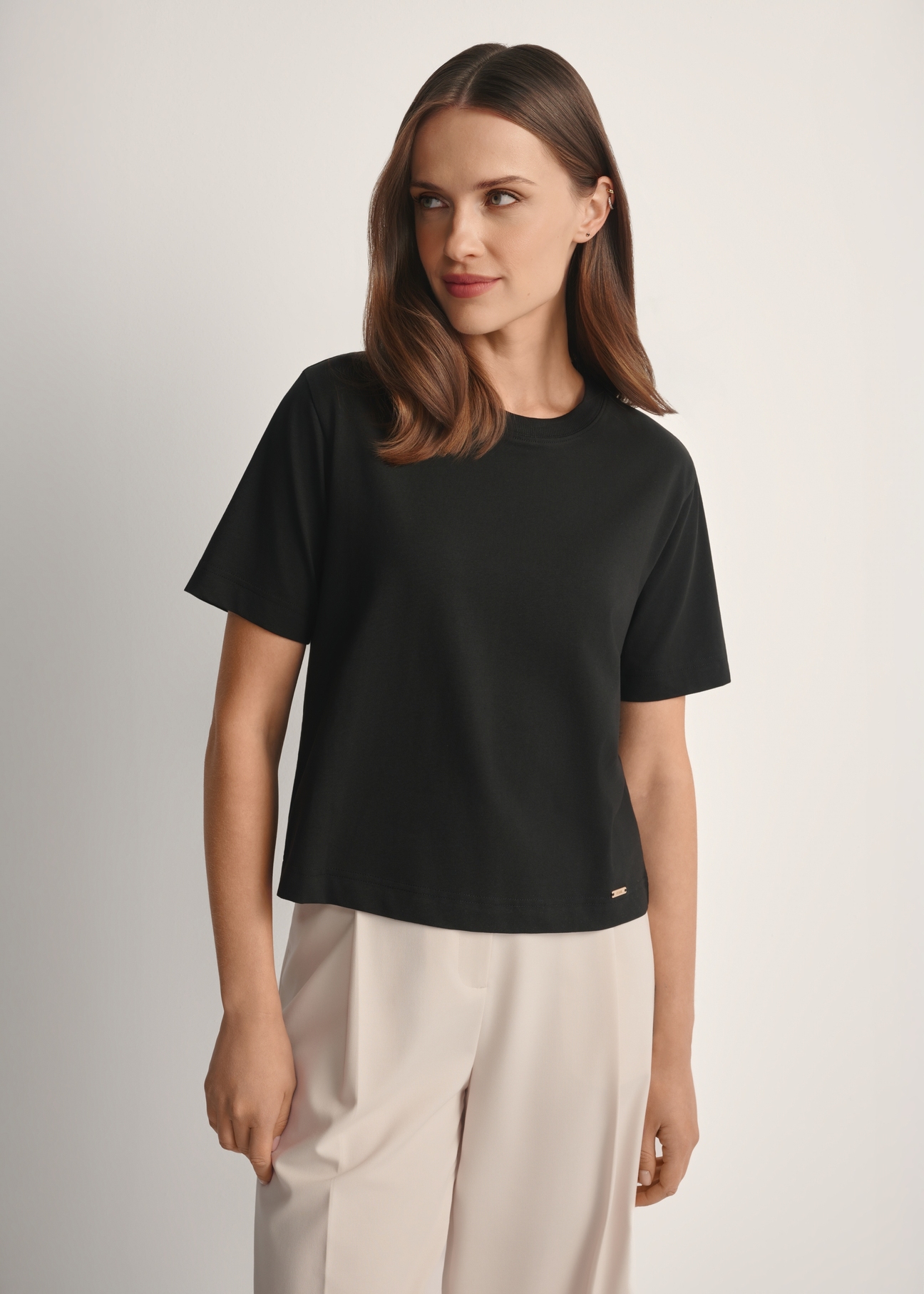 Bawełniany czarny T-shirt damski TSHDT-0138-99(W25), widok produktu od przodu na modelce, widoczna połowa sylwetki.