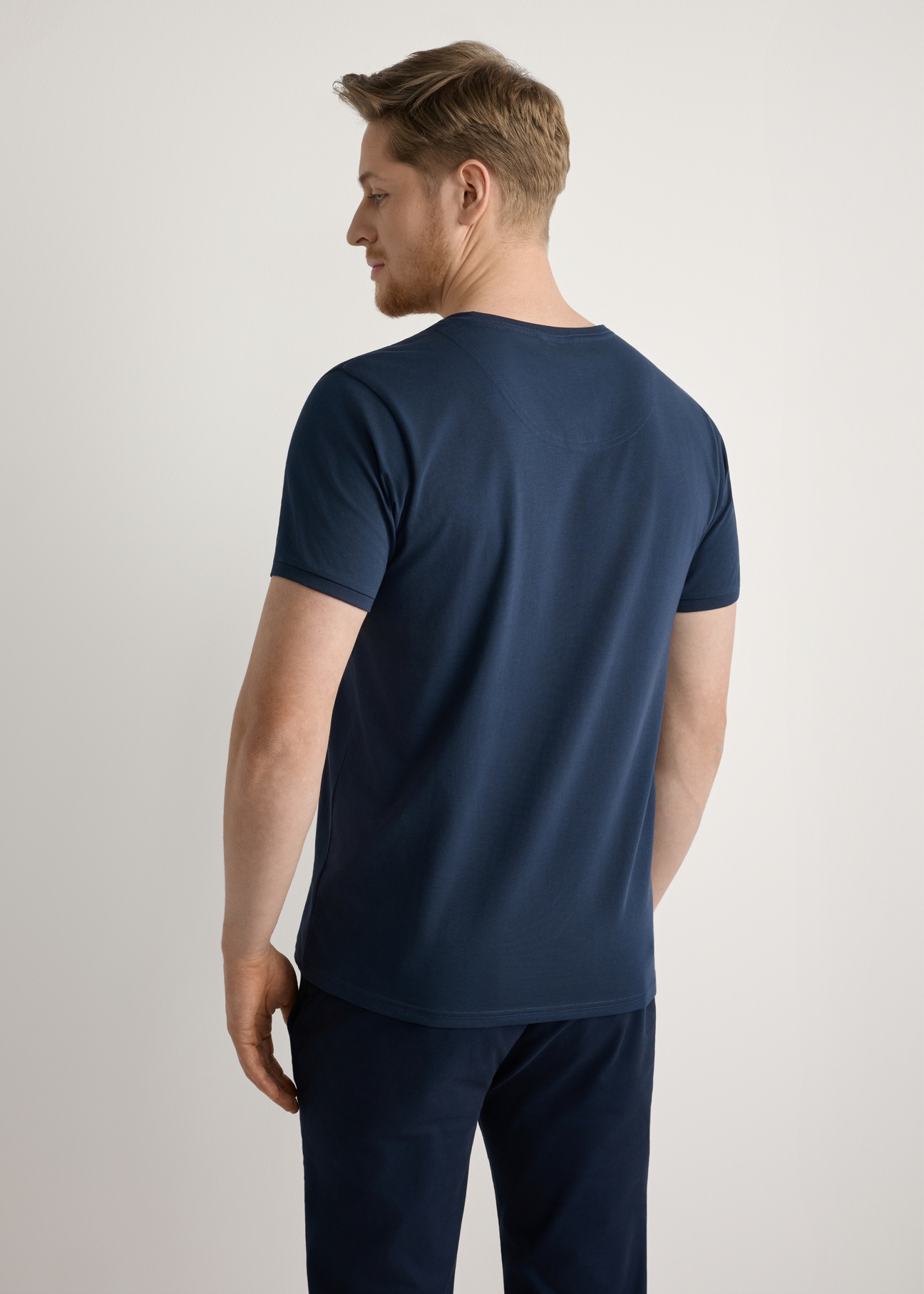 Granatowy bawełniany T-shirt męski TSHMT-0088-7E(W26), widok produktu od tyłu na modelu, widoczna połowa sylwetki.
