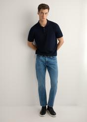 Ciemnoniebieskie spodnie jeansowe męskie JEAMT-0021-7H(W26), widok produktu z przodu na modelu. Widoczna cała sylwetka.