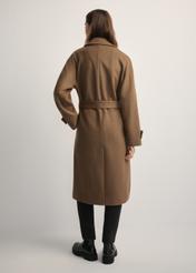 Wełniany płaszcz damski camelowy PLADT-0061-24(Z25) - widok produktu z tyłu, na modelce, na jasnym tle.  Widoczna cała sylwetka.