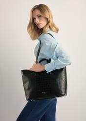 Czarna torebka damska shopper TOREC-1204-9G(W26), widok produktu na ramieniu modelki. Widoczna połowa sylwetki.