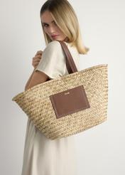 Słomkowa torebka damska typu shopper TOREC-1219-1E(W26), widok produktu z przodu, na modelce, na jasnym tle. 