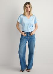 Jasnoniebieska bluzka damska BLUDT-0206-7A(W26), widok produktu z przodu na modelce. Widoczna cała sylwetka.