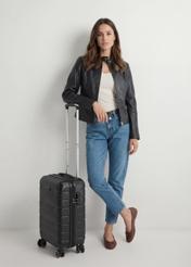 Walizka mała na kółkach WALAB-0067-99-19(W25), widok produktu skosem przy modelce, widoczna cała modelka.