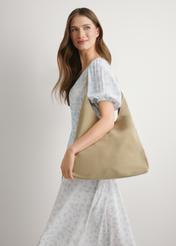 Skórzana torebka shopper w kolorze kremowym TORES-1307-0B(W26), widok produktu na ramieniu modelki. Widoczna połowa sylwetki.