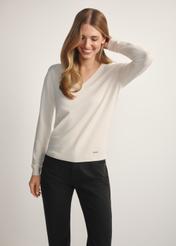 Kremowy sweter z dekoltem V-neck SWEDT-0201-0B(W26), widok produktu z przodu na modelce. Widoczna połowa sylwetki.