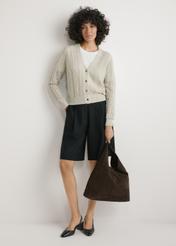 Skórzana torebka shopper w kolorze ciemnobrązowym TORES-1307-1I(W26), widok produktu w dłoni modelki. Widoczna cała sylwetka.