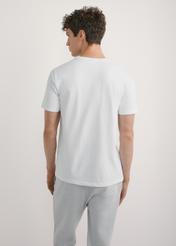 Biały T-shirt męski TSHMT-0137-0A(W26) - widok produktu z tyłu, na modelu, na jasnym tle. Widoczna sylwetka do kolan. 