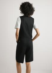 Czarna kamizelka z wiskozy i lnu KAMDT-0038-99(W26) - widok produktu z tyłu, na modelce, na jasnym tle, Widoczna połowa sylwetki.