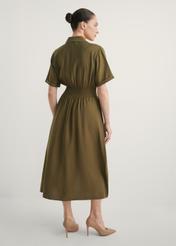 Sukienka midi w kolorze khaki SUKDT-0257-8D(W26), widok produktu z tyłu na modelce. Widoczna cała sylwetka.