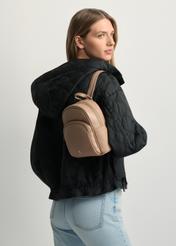 Beżowy skórzany plecak damski TORES-1089A-1B(W26) - widok produktu po skosie, na modelce, na jasnym tle. Widoczna połowa sylwetki.