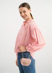 Niewielka różowa torebka na łańcuszku TOREC-1013-34(W25) - widok na modelce na białym tle. Widoczna połowa sylwetki. 