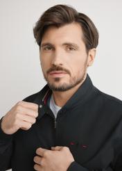 Czarna lekka kurtka przejściowa męska KURMT-0370-99(W25), zbliżenie na produkt na modelu, na jasnym tle.