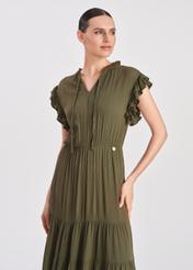 Długa sukienka w kolorze khaki SUKDT-0187-54(W25), widok produktu na modelce. Widoczna połowa sylwetki.